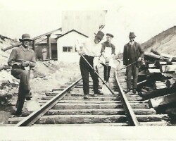 Who are they? Where are they? When? What are they doing? Is this a significant event? Four men on railroad track