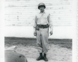 Who is this man? Where was it taken? When? What do his clothes indicate? What about the auto? Man in military-type clothes